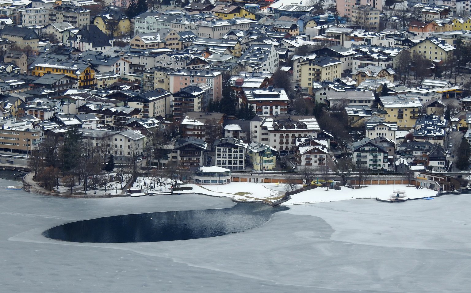 Blick über Zell am See mit dem teilweise zugefrorenen Zeller See und der Stadt im Winter